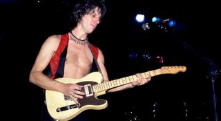 A shirtless Jeff Beck plays his custom Tele-Gib onstage in Michigan, 1980