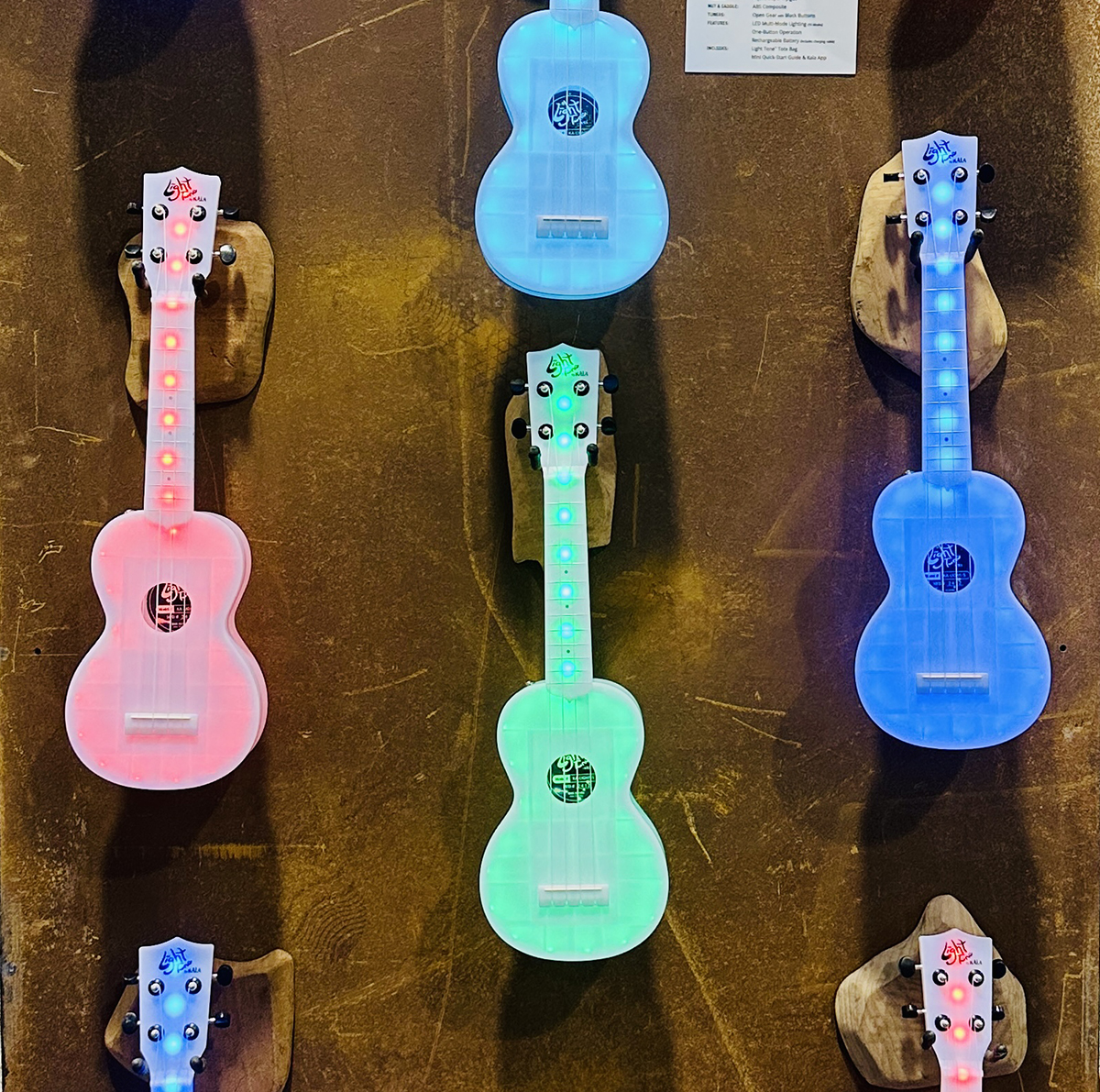 A photo showing several Kala Light Tone Color-Changing Ukuleles on display at NAMM 2025