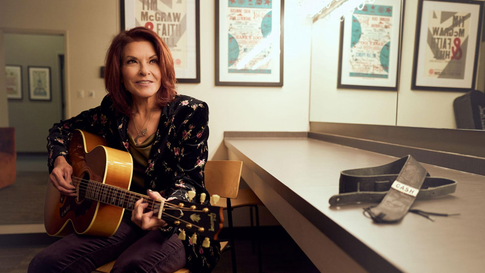 Rosanne Cash playing her Gibson acoustic guitar – her 'Cash' strap lies beside her on a table