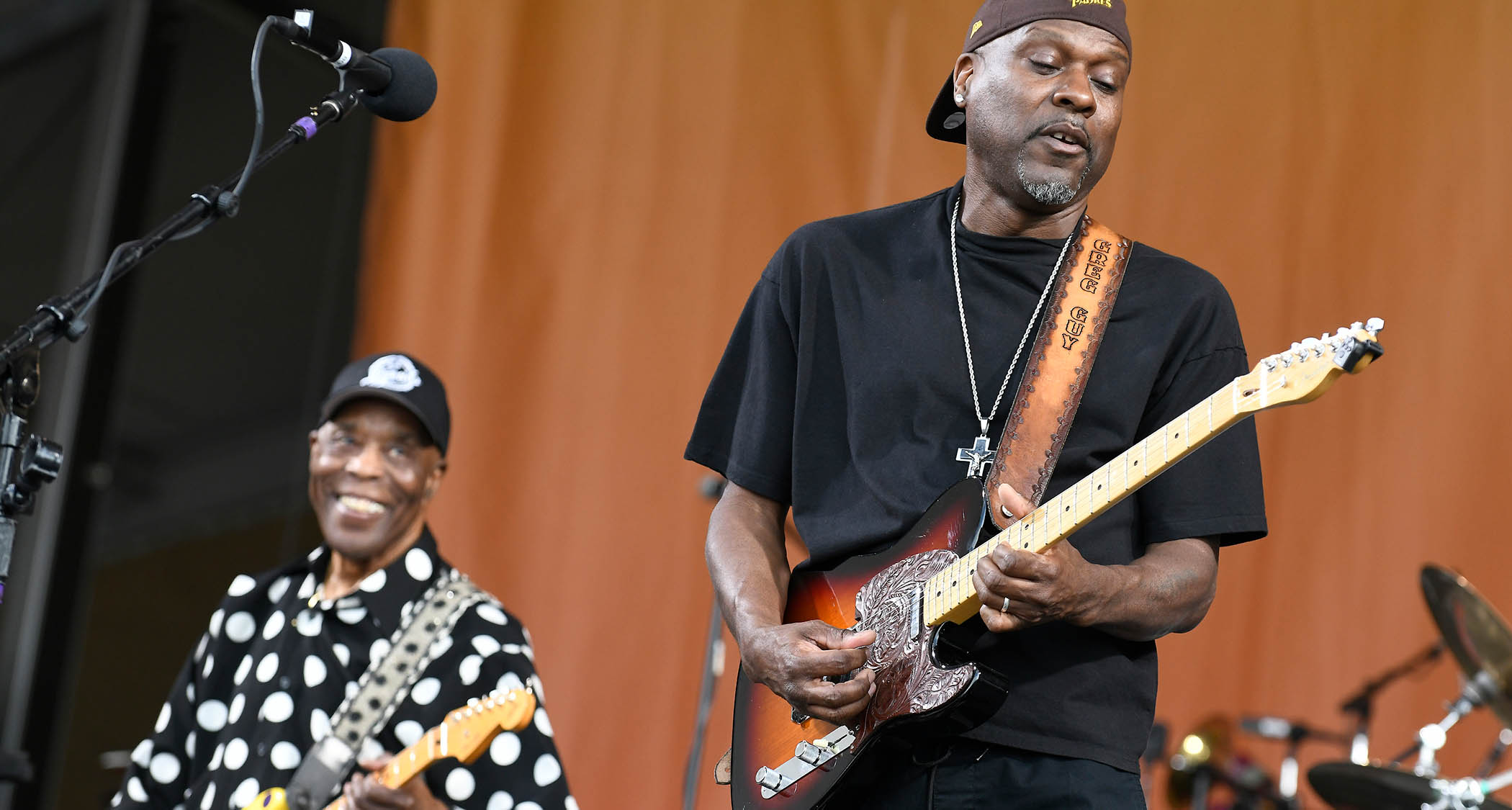 Buddy Guy and son Greg perform onstage together, with Greg taking a solo on his Telecaster and Buddy looking on with pride – he wears his trademark polka-dotted shirt.