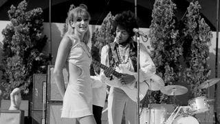 Jimi Hendrix plays his Fender Stratocaster electric guitar onstage as a woman looks on during soundcheck for his performance at the Hollywood Bowl on August 18, 1967 in Los Angeles, California.