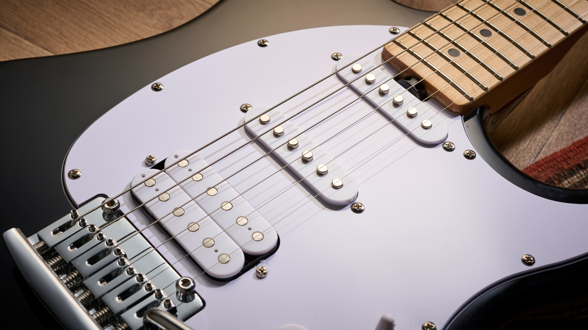 Sterling By Music Man Intro Series Cutlass: the entry-level double-cut electric is finished in gloss black, has a three-ply white pickguard and a maple fingerboard with black dot inlays.