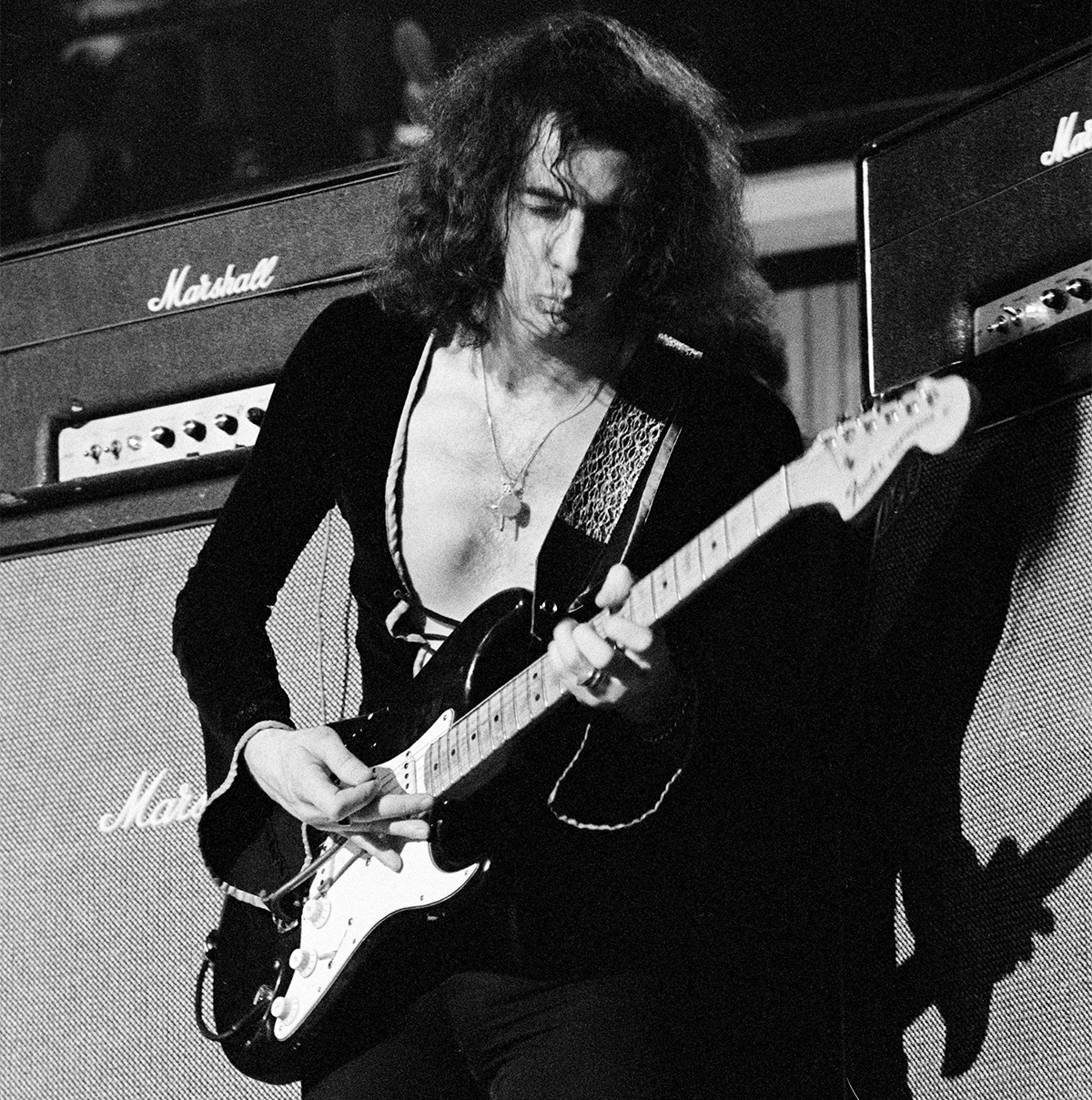 Ritchie Blackmore performing live onstage, playing Fender Stratocaster guitar, with Marshall amplifier behind