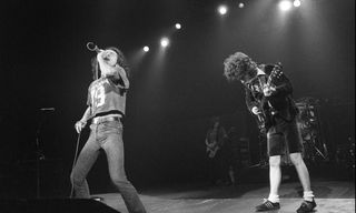 Bon Scott (left) and Angus Young perform onstage with AC/DC at the Hammersmith Odeon in London on November 1, 1979