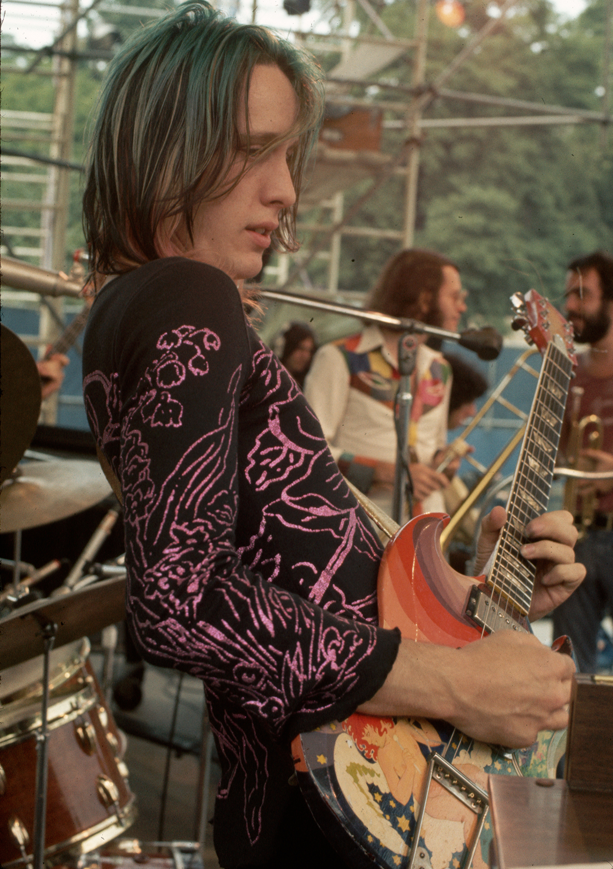 Rock and roll guitarist Todd Rundgren playing his specially-decorated guitar on stage in concert.