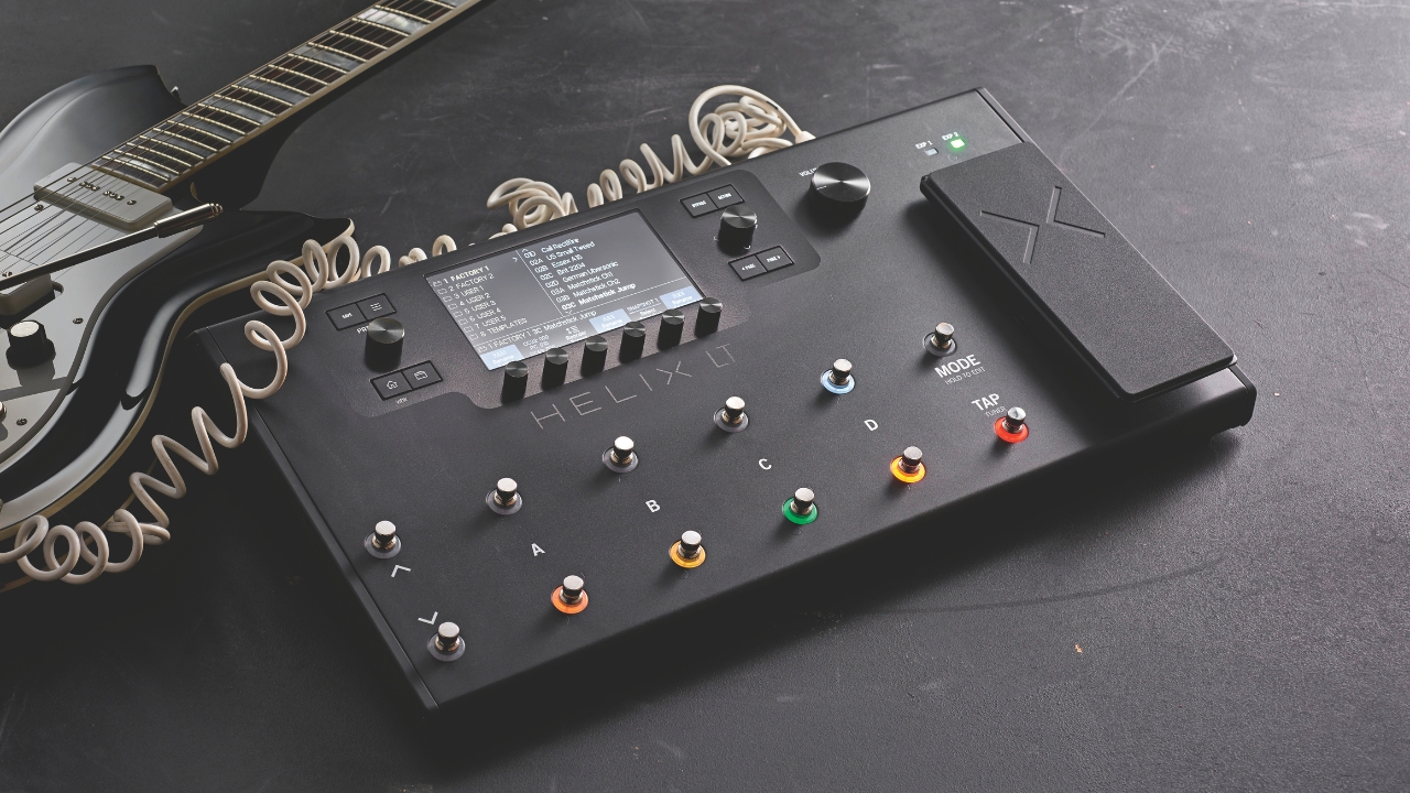 A Line 6 Helix LT amp modeler on the floor with an electric guitar