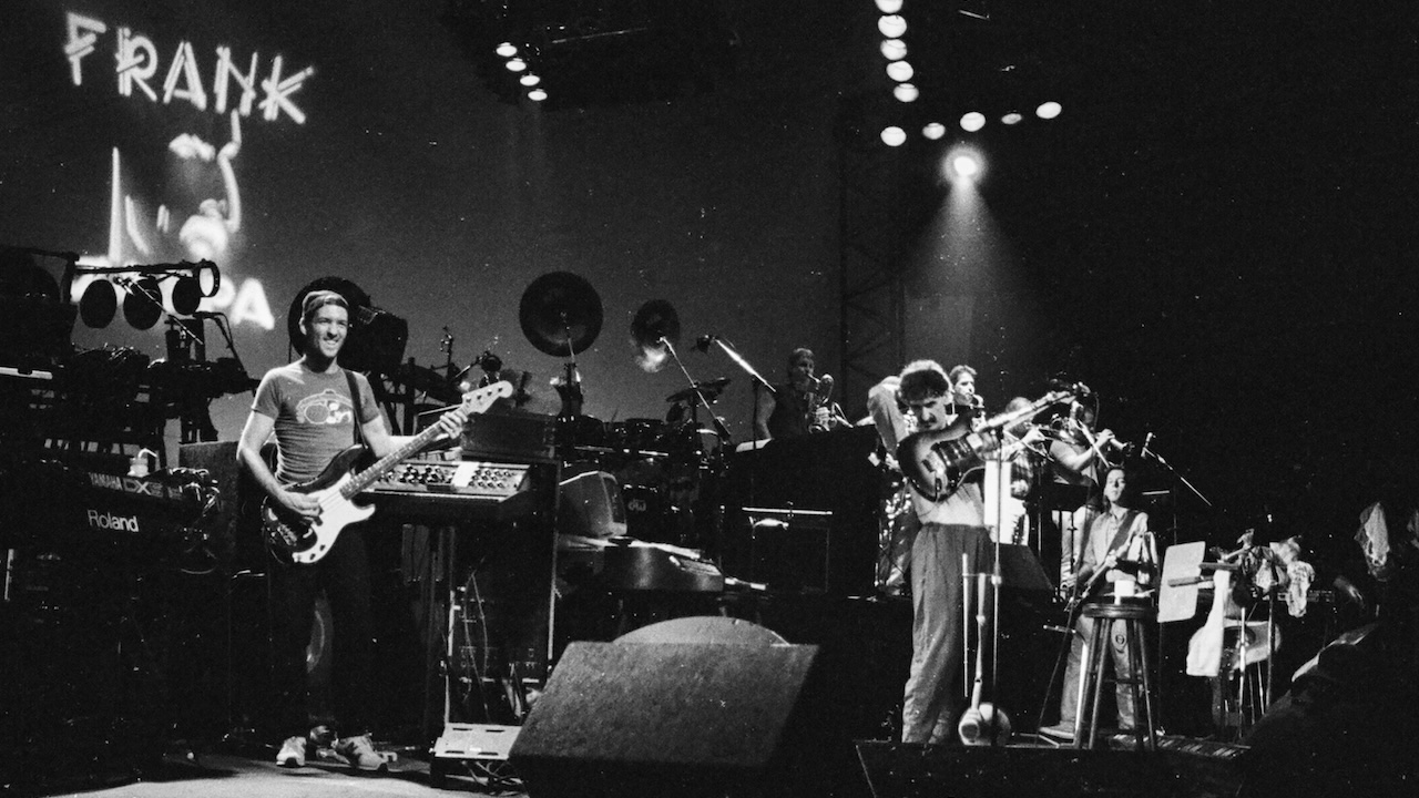 American Rock, Jazz, & Experimental musician, composer, & bandleader Frank Zappa (1940 - 1993) (fore, second left) plays guitar as he performs, with his band, on stage at the Beacon Theatre, New York, New York, February 2, 1988.
