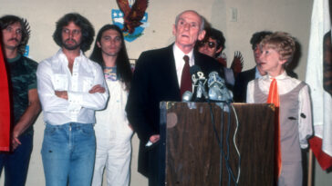 Joe Walsh, Don Felder, Timothy B. Schmit, Alan Cranston, Don Henley, Glenn Frey, and Cranston's wife Norma Weintraub attend an event in 1980