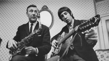 Pete Townshend of The Who pictured playing an acoustic guitar with his father Cliff Townshend (1916-1986), saxophone player with the Squadronaires, at home in London on 30th March 1966.