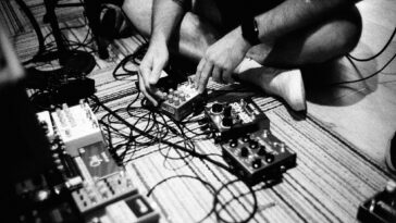 A black-and-white picture of Deafheaven experimenting with guitar pedals