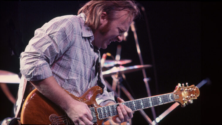Stephen Stills plays guitar in concert with his band Crosby Stills and Nash, 1970