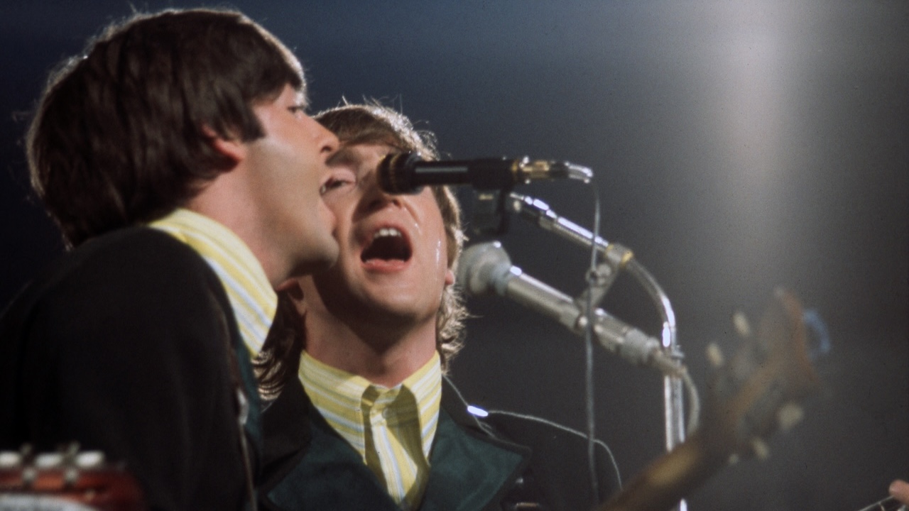 Paul McCartney and John Lennon (1940-1980) of the Beatles perform on stage at Circus-Krone-Bau, June 24, 1966, Munich, West Germany.