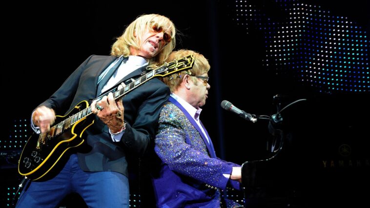"Davey Johnstone Reflects on Guitar Shopping with Elton John: How He Landed His Iconic Les Paul Custom After a Memorable Moment at the Store"]