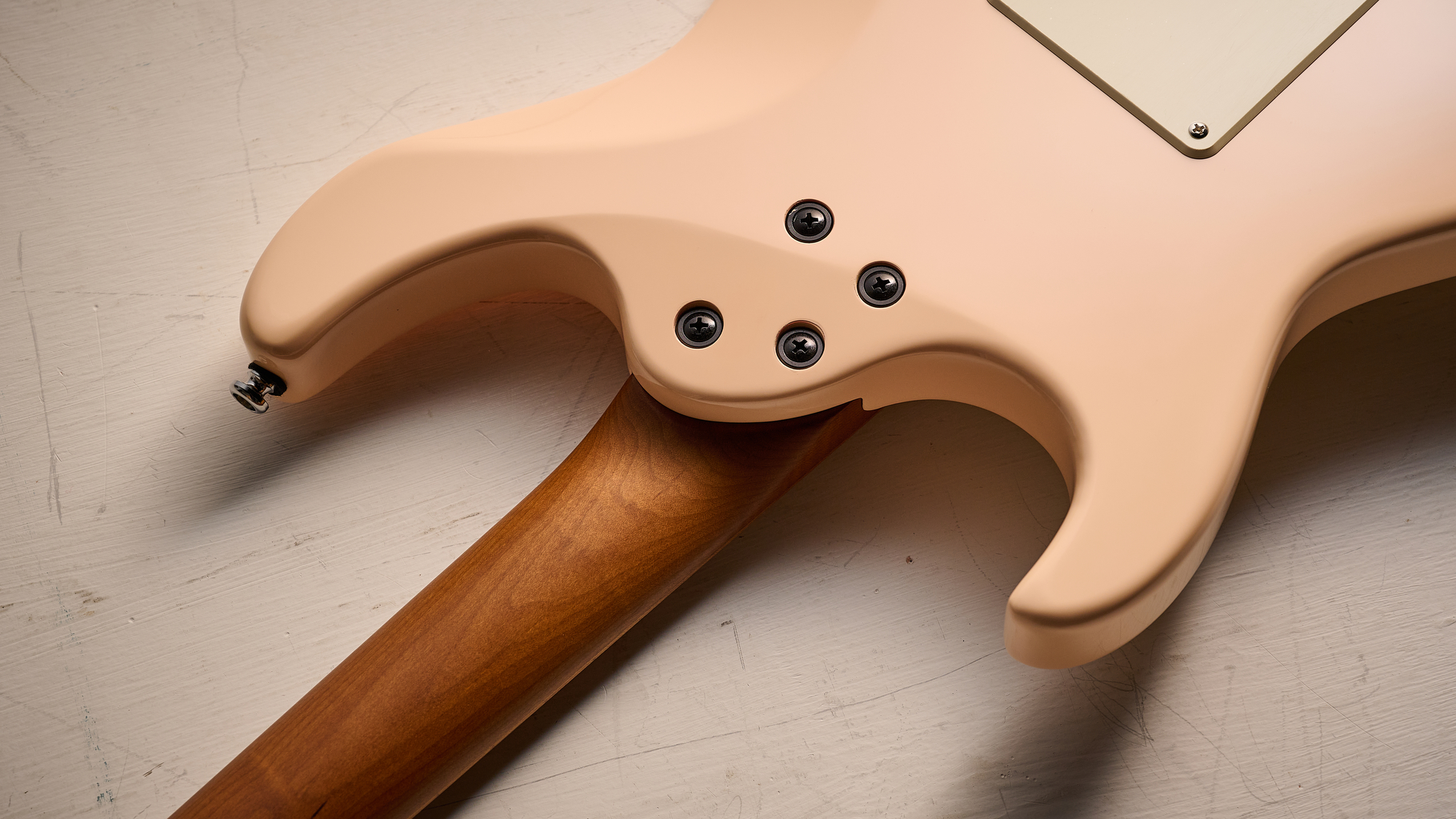 The sculpted neck heel of a Cort G200SE electric guitar