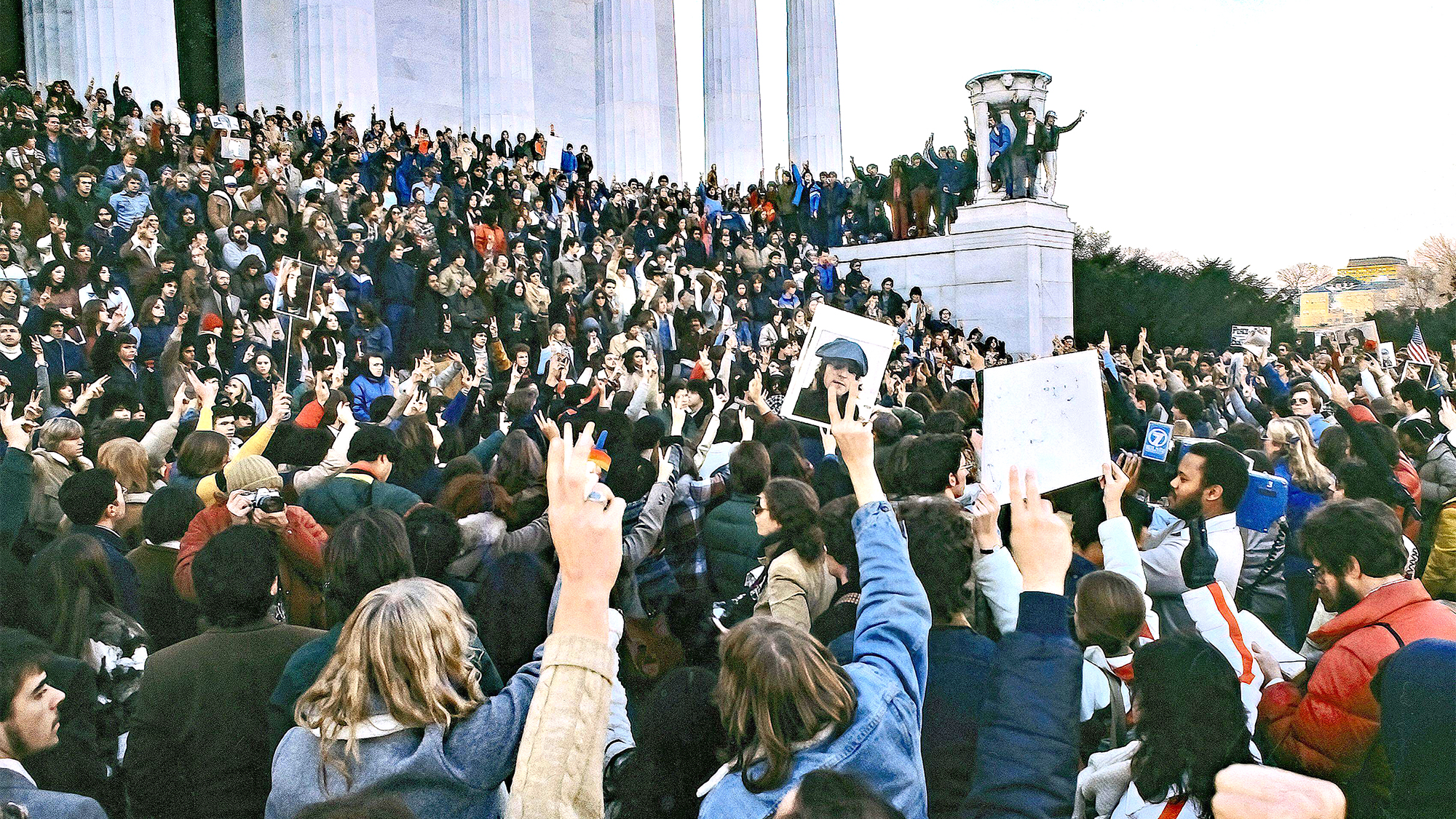 Crowd of mourners holding photos of slain Beatle John Lennon gather on the front steps of the Lincoln Memorial on December 10, 1980, 2 days after he was assassinated in New York by Mark David Chapman