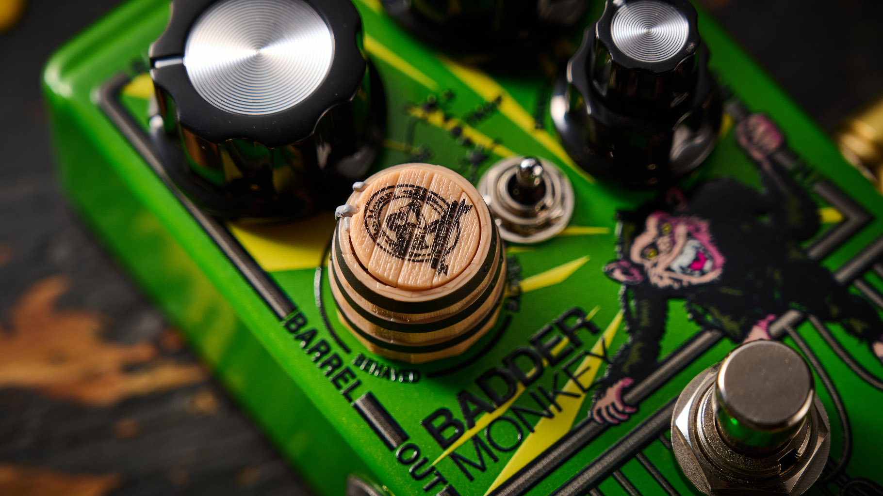 The DOD Badder Monkey is another little green overdrive pedal &ndash; but like no other. Pictured here against a distressed wooden floor, it has a wooden barrel control, and a primate illustration on the front.