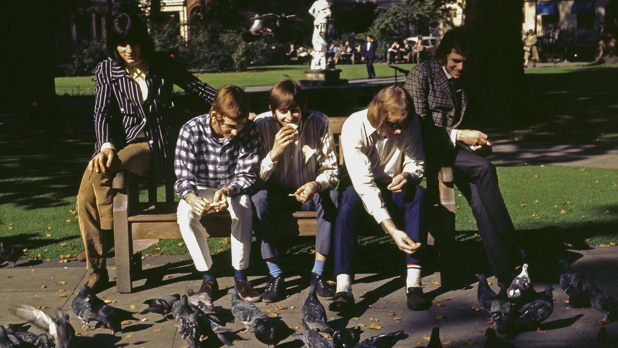 Photo of BIRDS and Ronnie WOOD and Ron WOOD and Kim GARDNER; Ron Wood (Ronnie Wood) on left - posed, group shot, feeding birds,