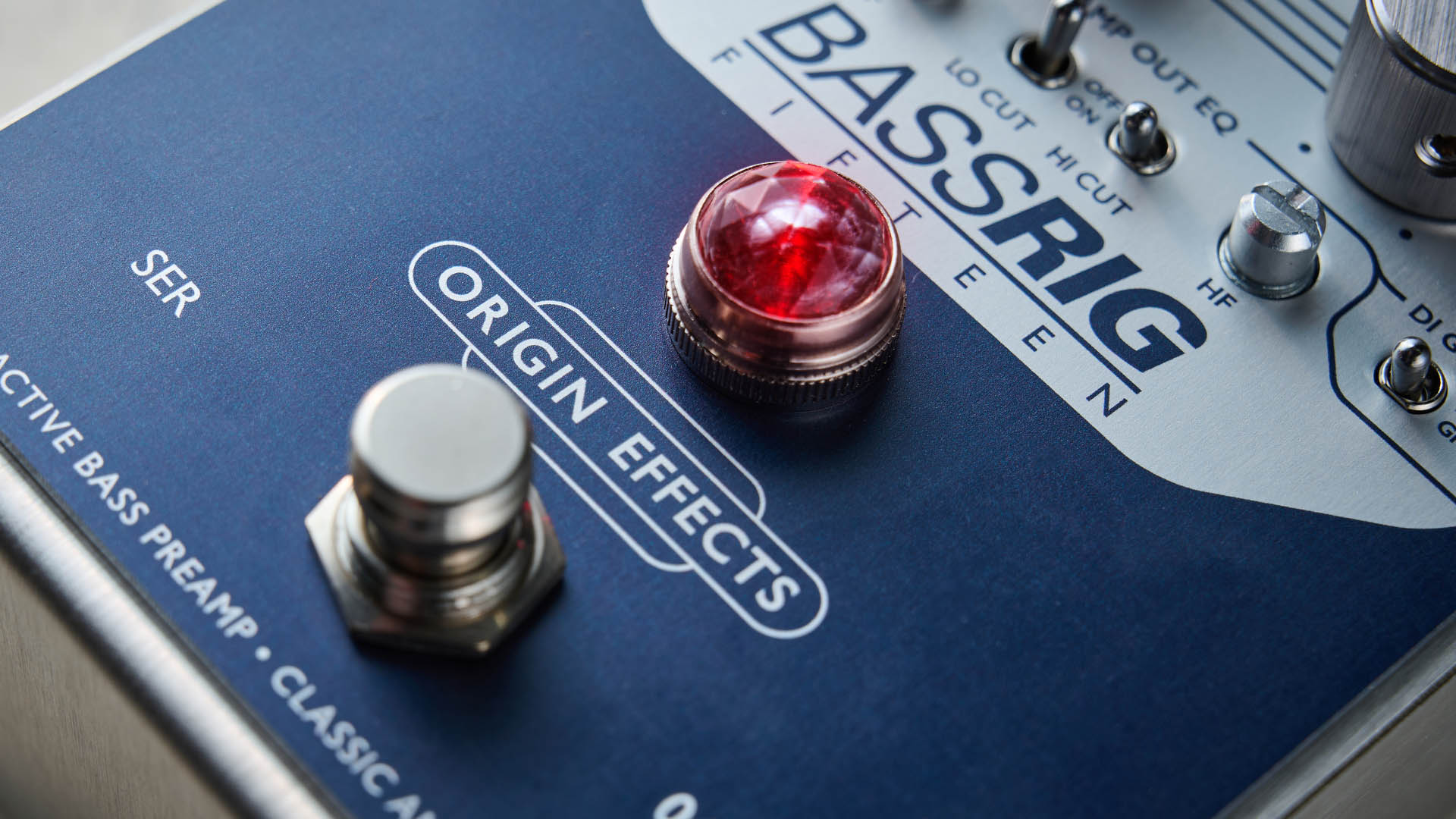 Origin BASSRIG 15: the classy bass pedal has a red jewel lamp just like a real amplifier and is photographed in close-up.