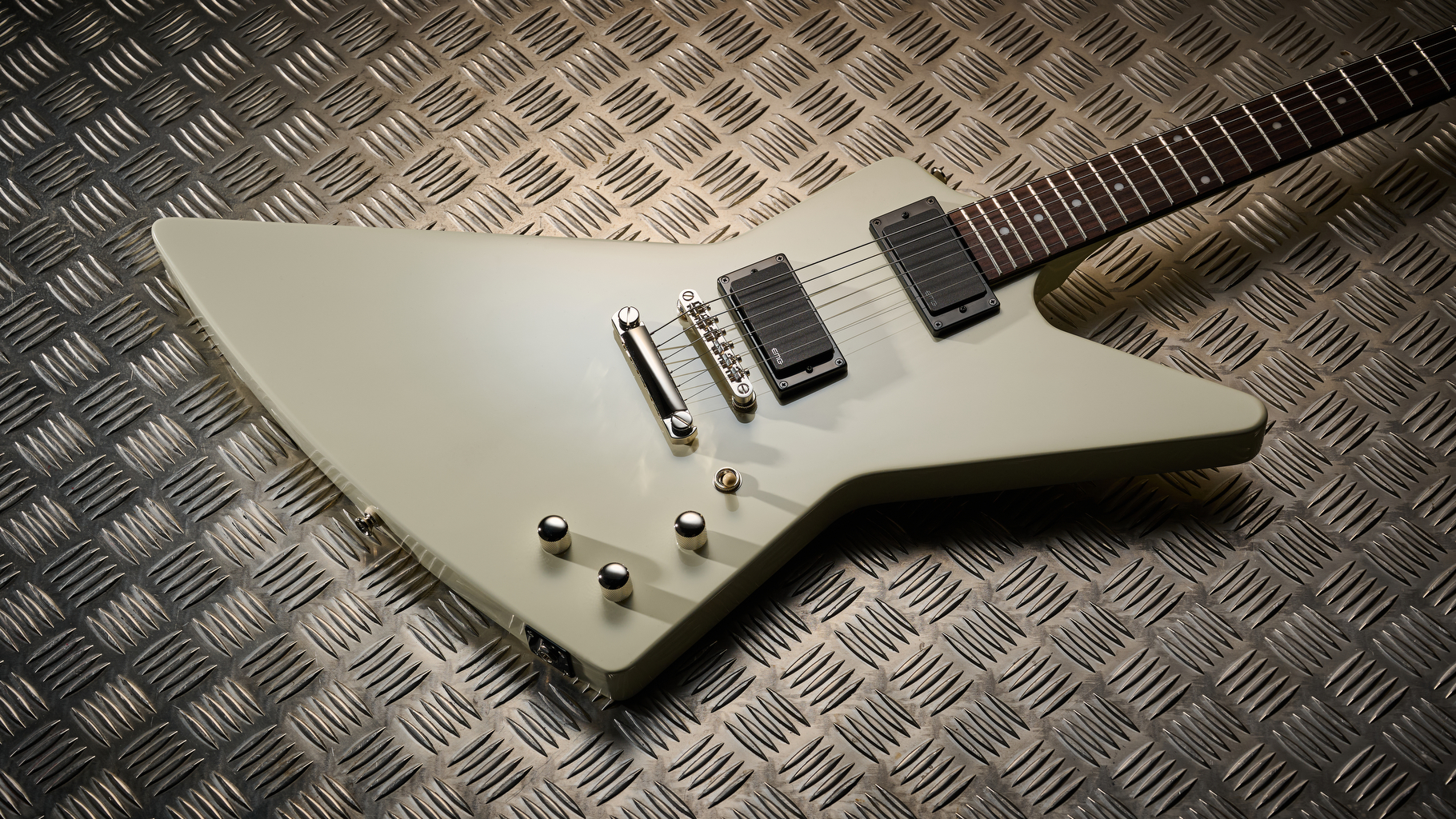 The body of an Epiphone Explorer 80s EMG electric guitar lying on some sheet metal