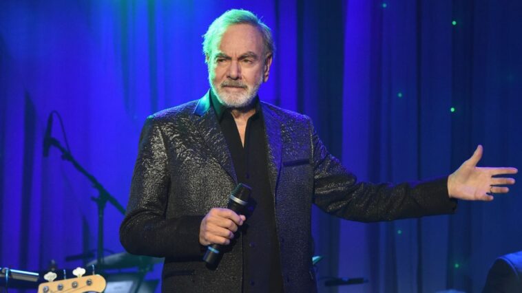 Neil Diamond presents a guitar to Hugh Jackman.]