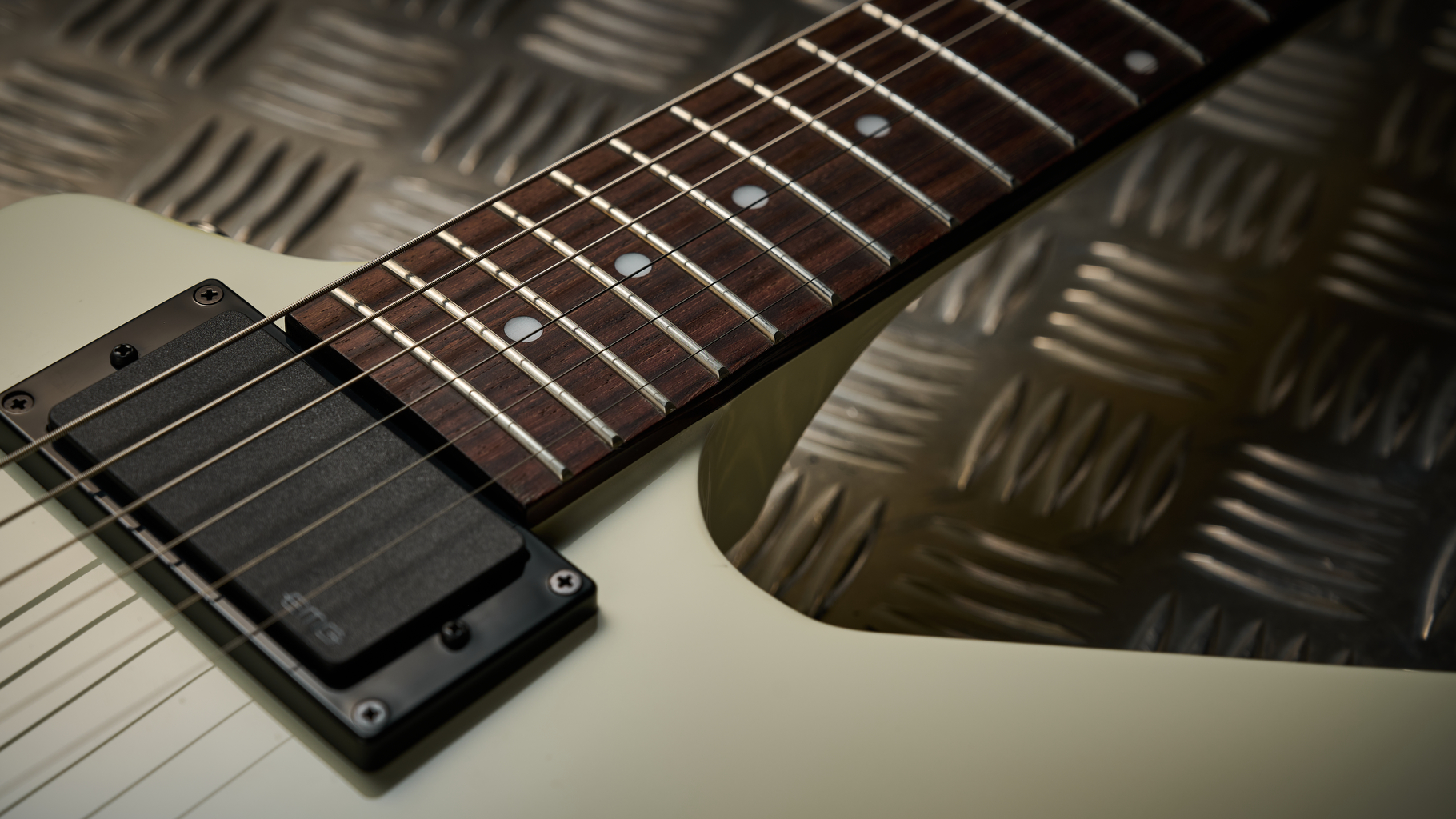 A humbucker and fretboard on the Epiphone Explorer 80s EMG electric guitar