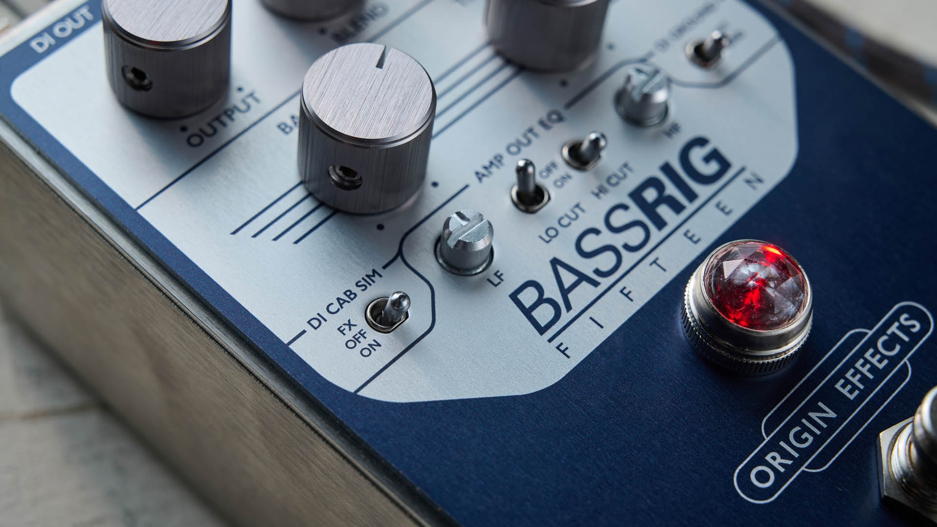 Origin BASSRIG 15: the classy bass pedal has a red jewel lamp just like a real amplifier and is photographed in close-up.