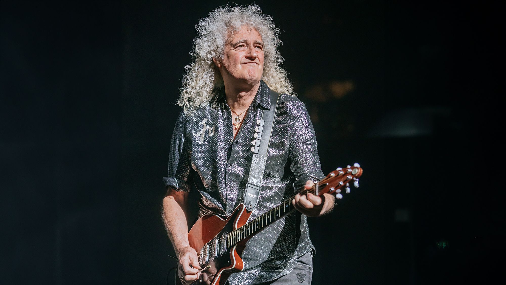 Brian May describes America as "too risky" for Queen's comeback.]