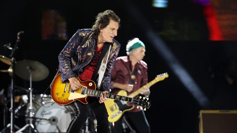 "Unveiling the Guitars: I grab one, strum, and it echoes Wild Horses – it's the very guitar from the song," says The Rolling Stones' guitar technician about the secrets to their live sound.]