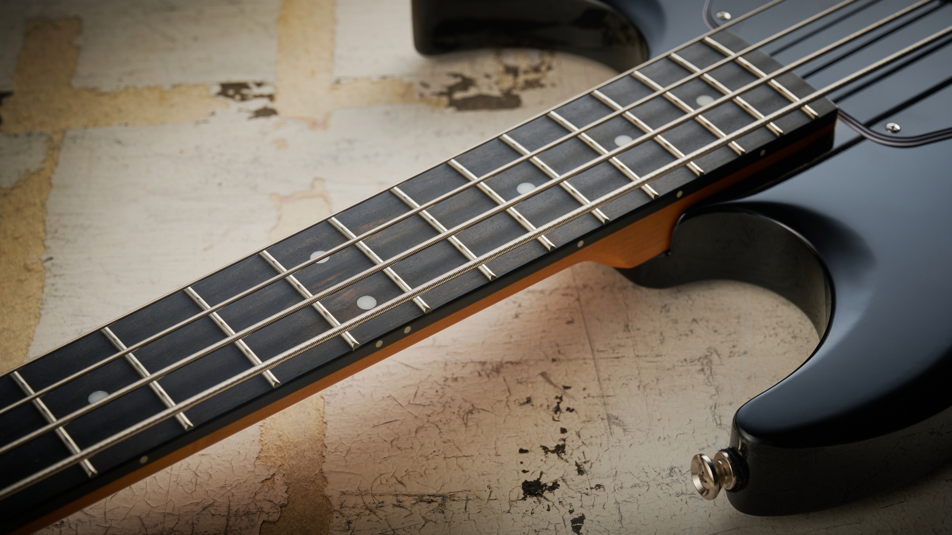 Epiphone Mike Dirnt Grabber G-3 in Silverburst finish photographed on scratched white board.