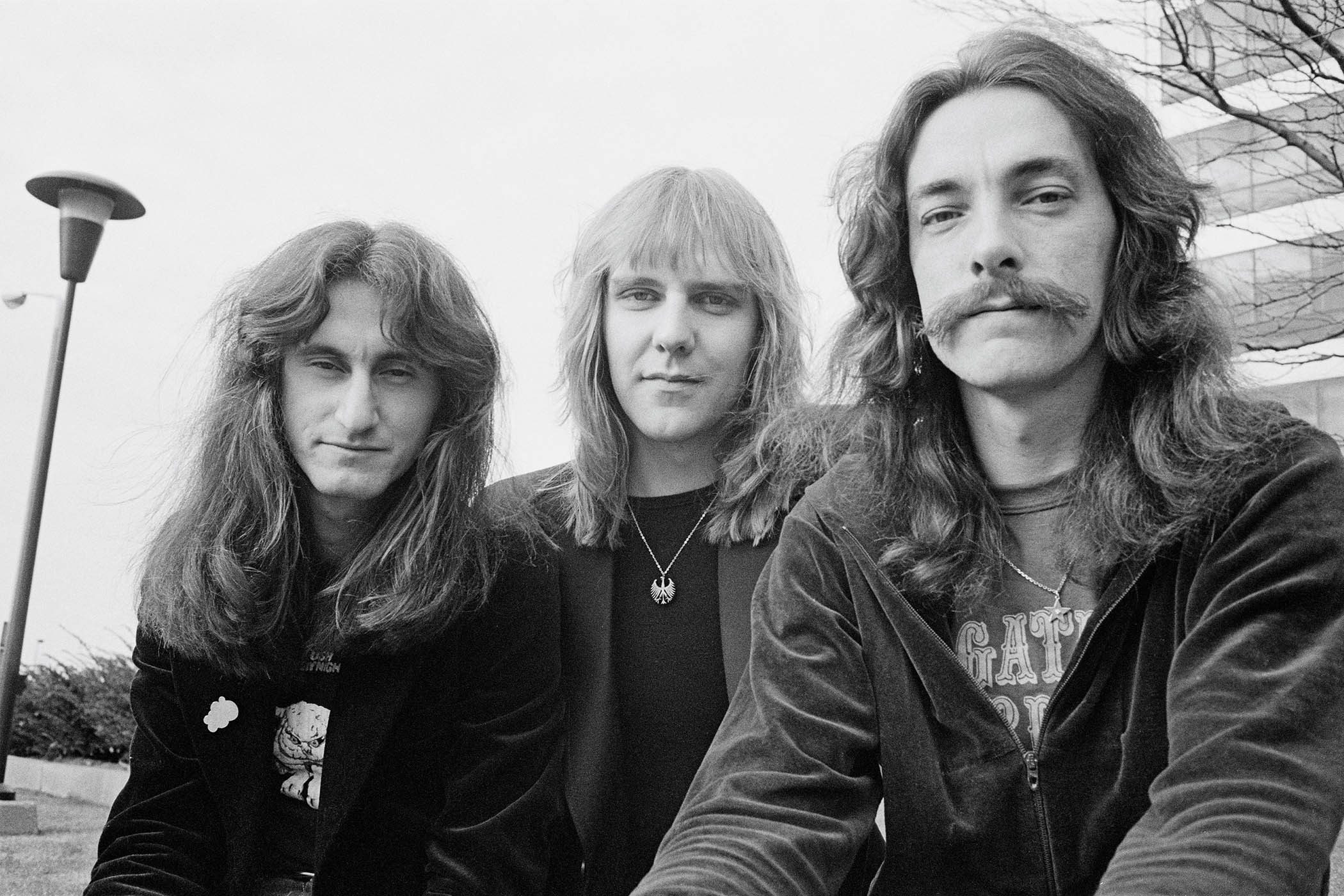 A black-and-white portrait of Rush in 1977 [L-R]: Geddy Lee, Alex Lifeson and Neil Peart.