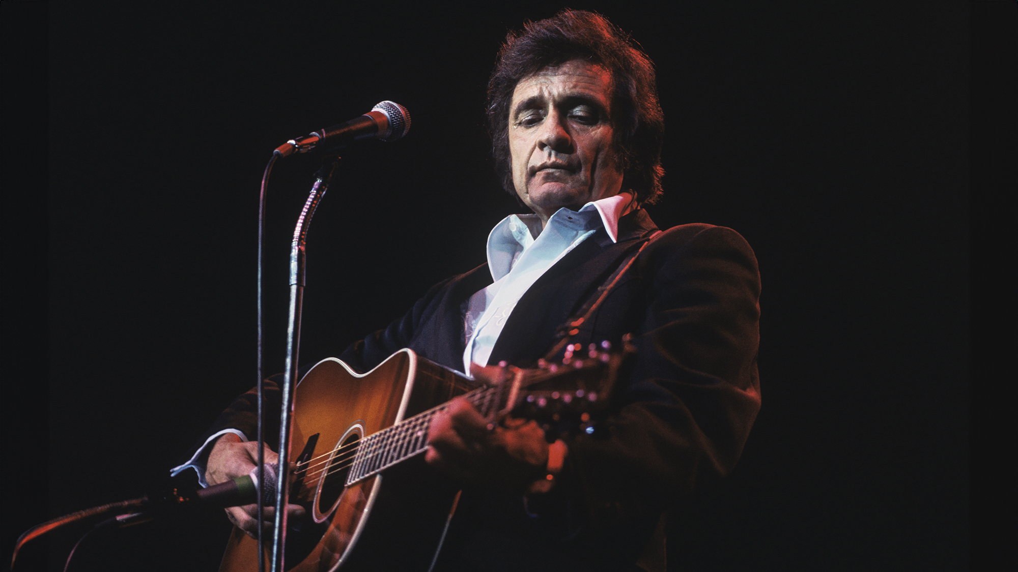 American singer Johnny Cash performs on stage at Wembley Arena, London in March 1979.