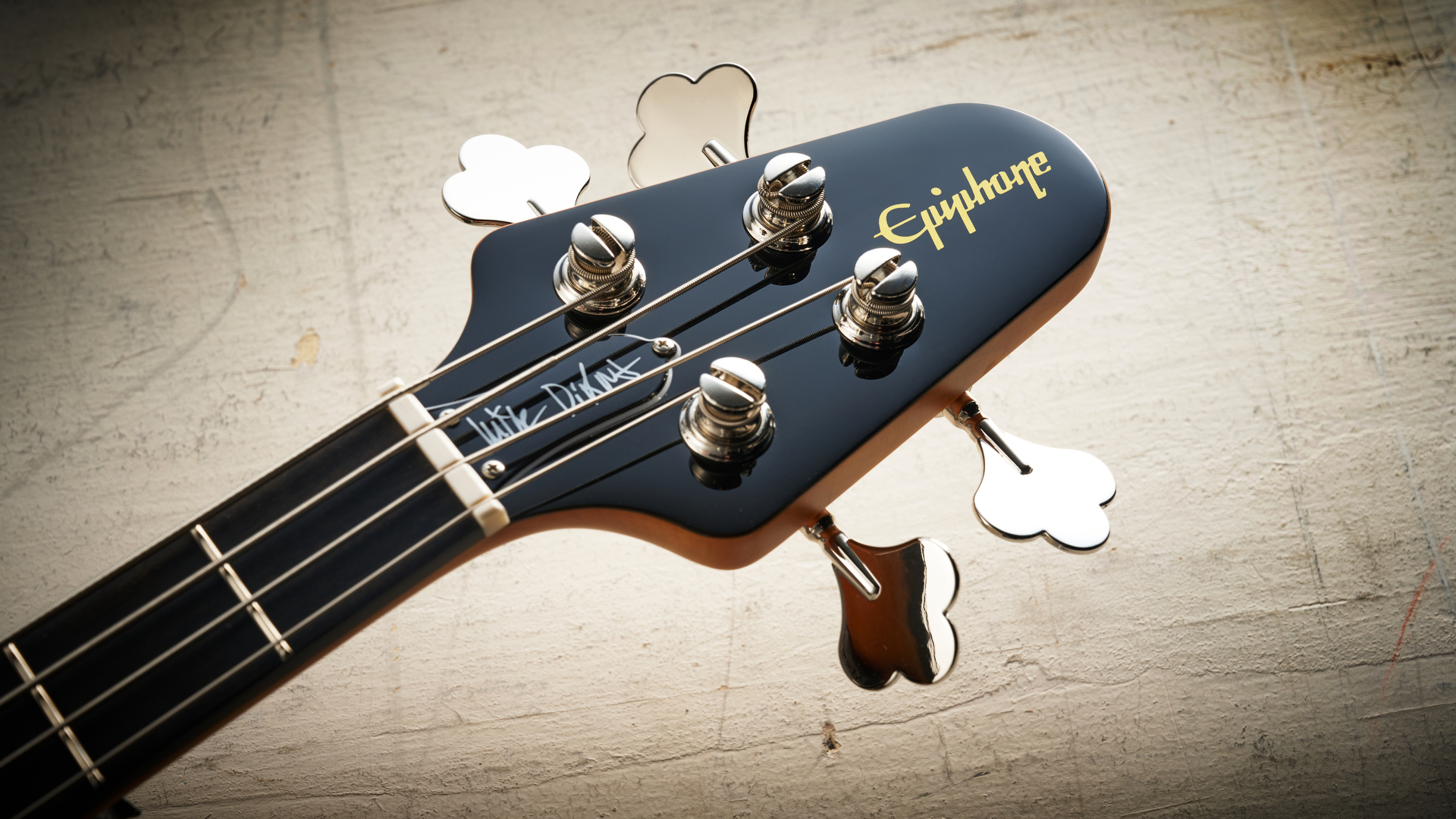 Epiphone Mike Dirnt Grabber G-3 in Silverburst finish photographed on scratched white board.