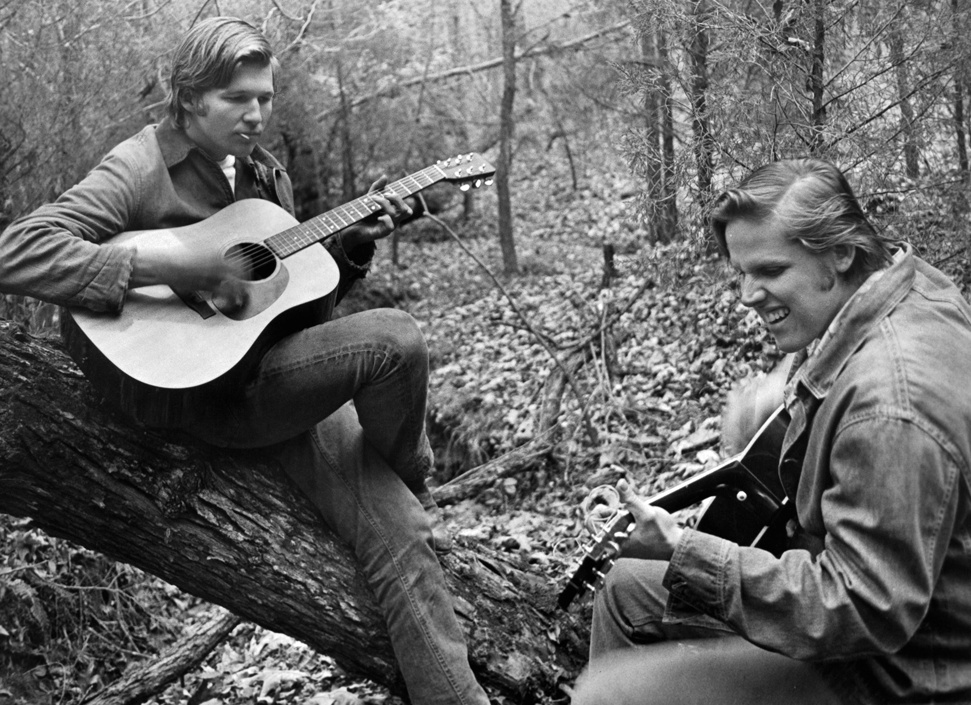 Jeff Bridges and Gary Busey play guitar in the woods in a scene from the film 'The Last American Hero', 1973.