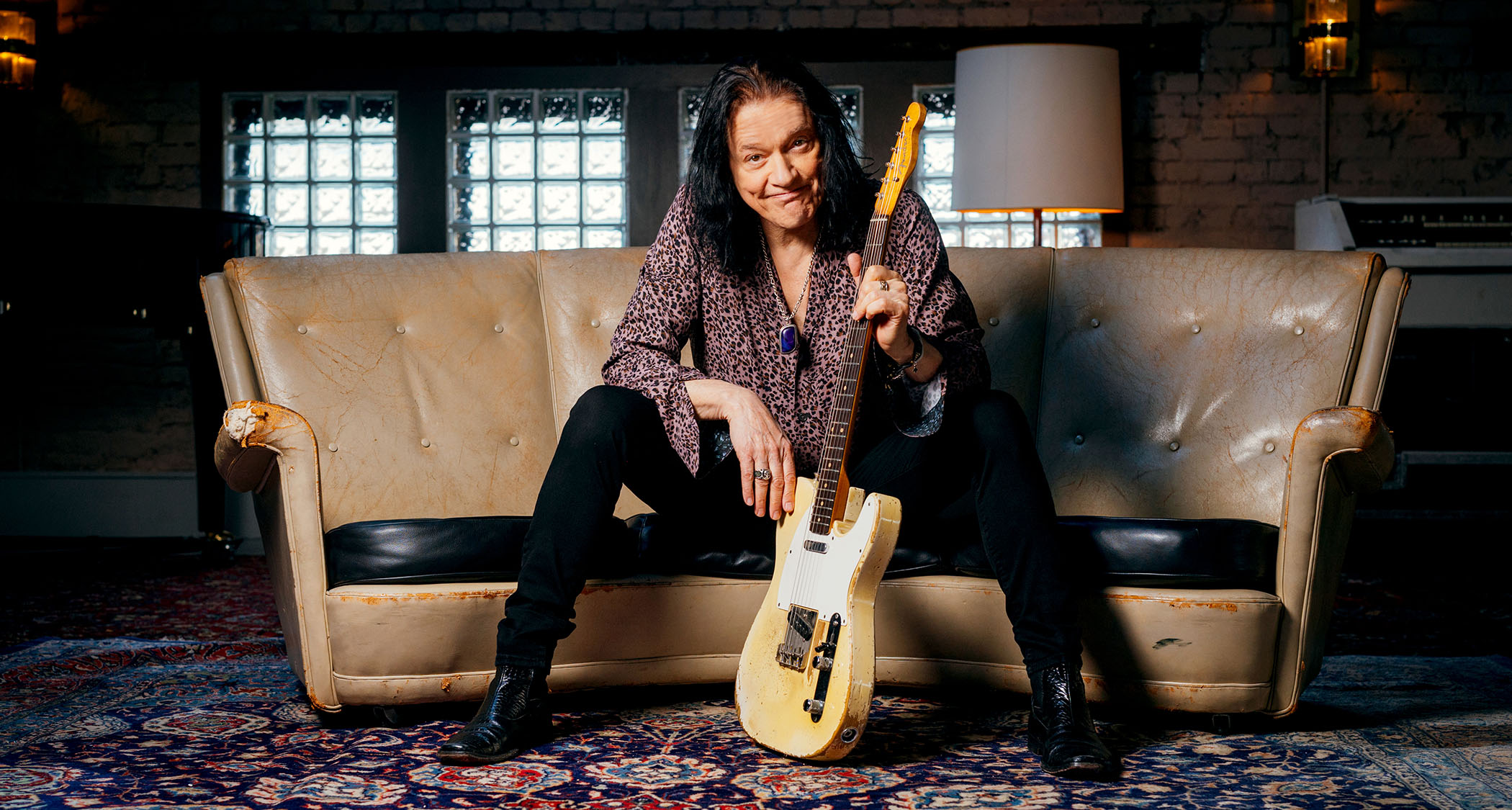 Robben Ford sits on a sofa with his trusty Fender Telecaster
