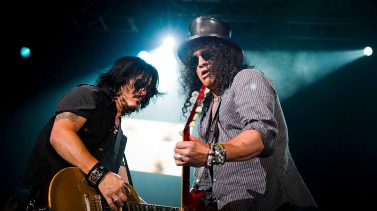Slash and Gilby Clarke perform a Guns N' Roses hit at charity event.]