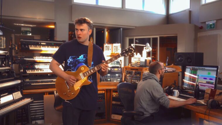 “Whenever I pick up a Les Paul, I just feel inspired to channel AC/DC”: Sam Fender shares exclusive footage of him crafting a guitar segment for his hit single “Rein Me In” featuring Olivia Dean.]