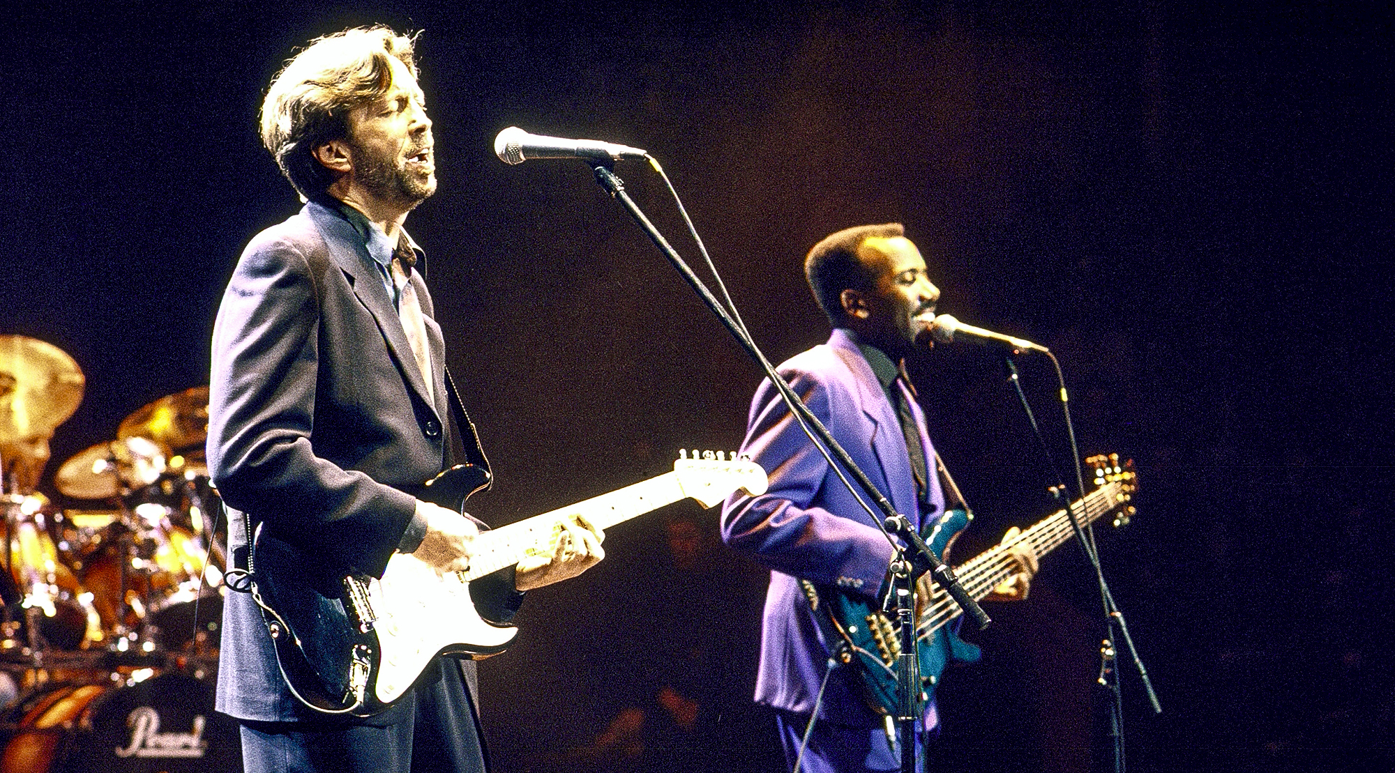 (L-R) Blues guitarist Eric Clapton &amp; jazz bassist Nathan East performing onstage.