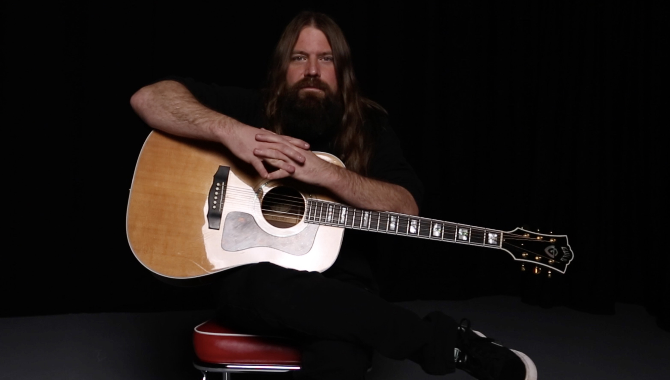 Mark Morton sits with his Guild dreadnought acoustic