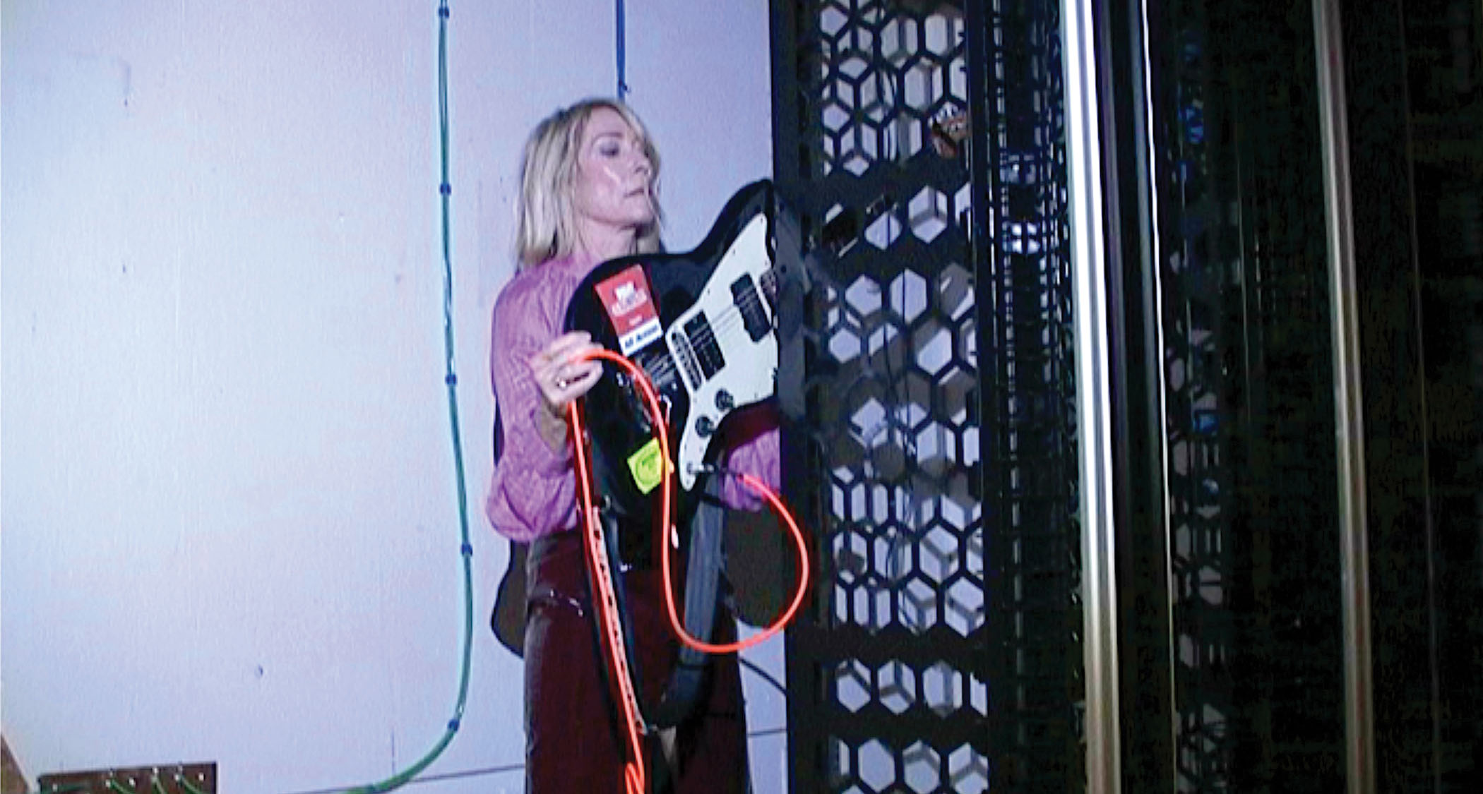 Kim Gordon rubs a Fender offset against the wall