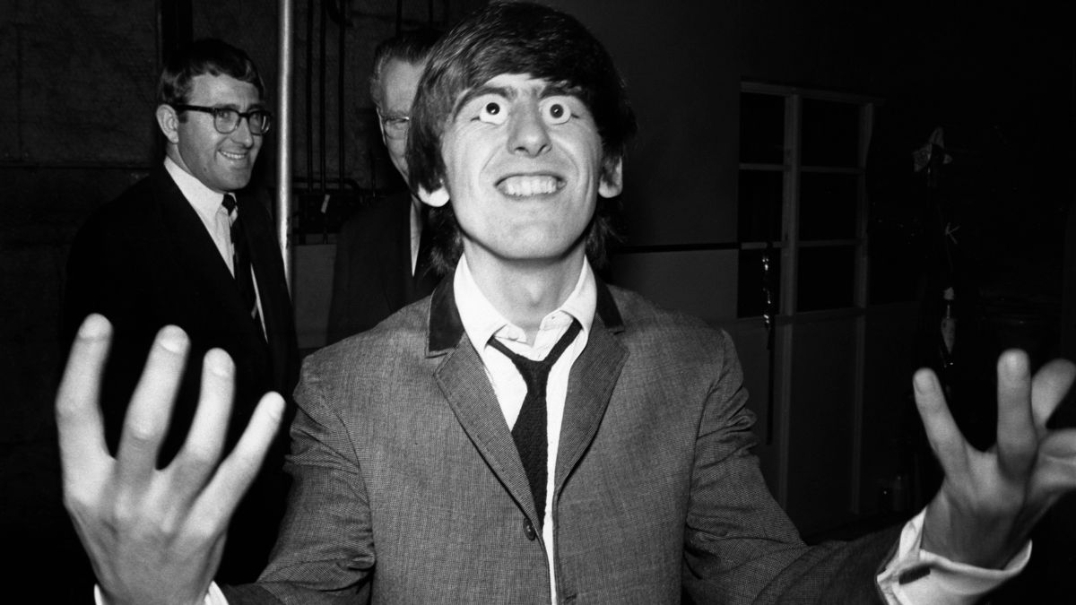 During a break in filming at Twickenham Studios George Harrison tries on a pair of false eyes from Madam Tussaud's wax works where models of The Beatles were being made.