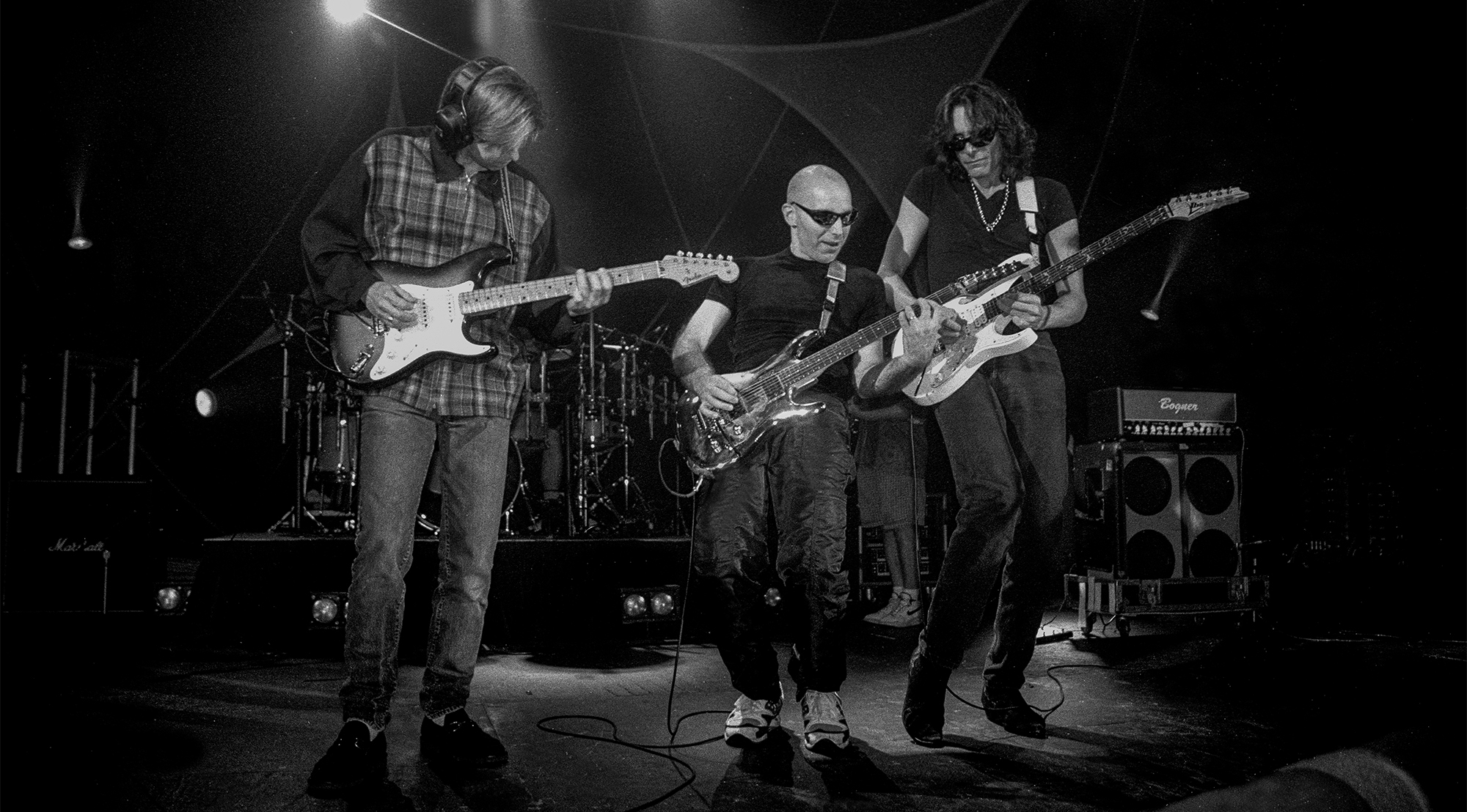 Eric Johnson, Joe Satriani and Steve Vai are shown performing on stage during a a "live" concert appearance with G3 on August 1, 1996.