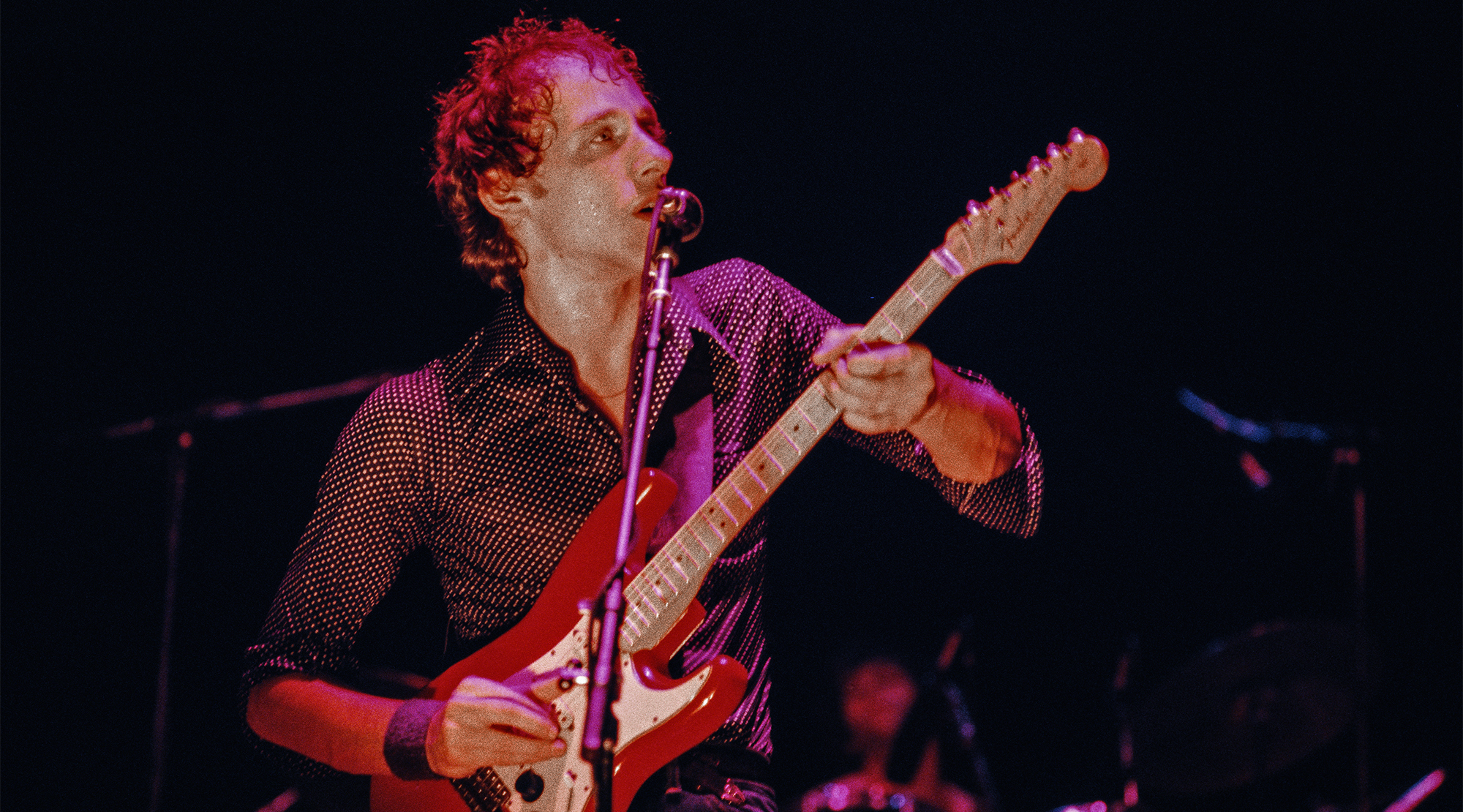 Mark Knopfler of the English rock band Dire Straits plays his red Fender Stratocaster guitar on stage at the Bottom Line in New York City on 3rd March, 1979.